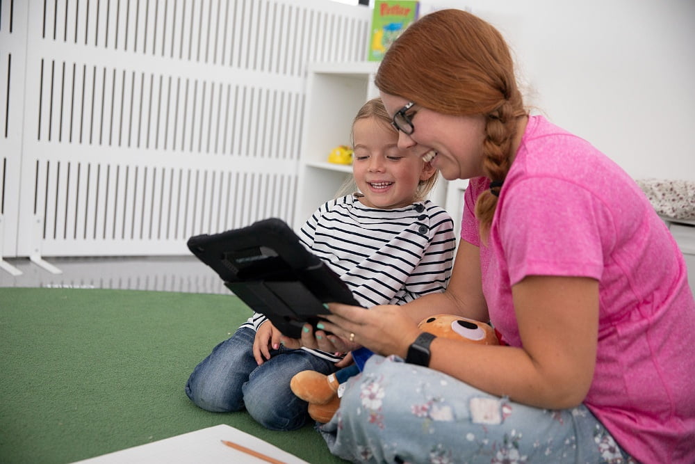 Kvinna läser med barn som går på förskola